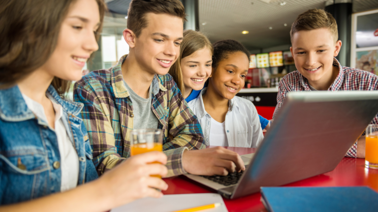 Grup de cinci copii între 13-16 ani se distrează învățând engleză la calculator în cadrul Cambridge Summer Course A2 - B1 la ILSE.